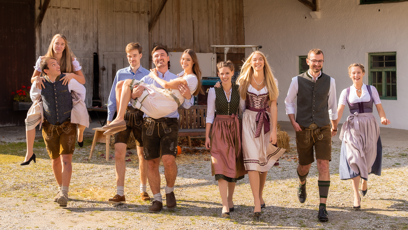 Familien in Tracht vor Bauernhof