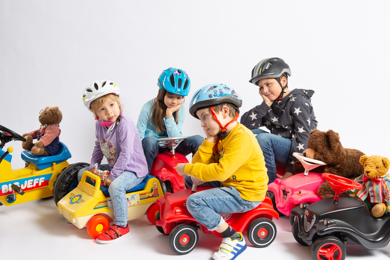 Kinder mit Bobbycars spielen Verkehrsstau