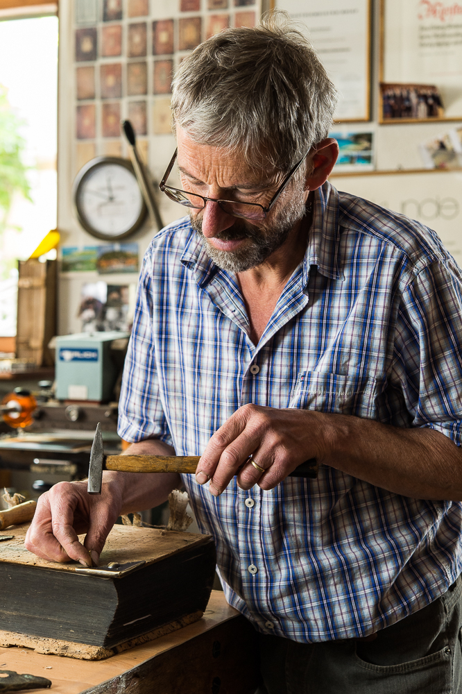 Buchbinder bei der Restauration eines historischen Bucheinbandes